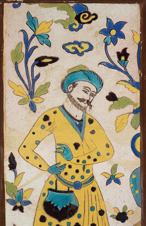 A glazed earthenware tile, Qajar dynasty Persia (Iran), 19th century. Man in yellow coat. Framed. Total dimensions 76 x 30 cm.