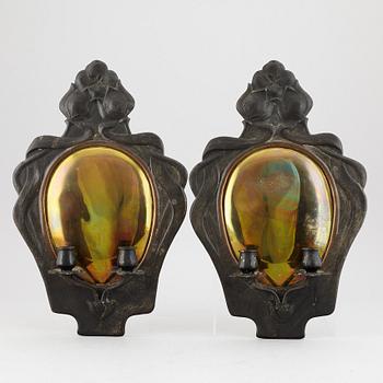 A pair of bronze and brass wall sconces from the early 20th century.
