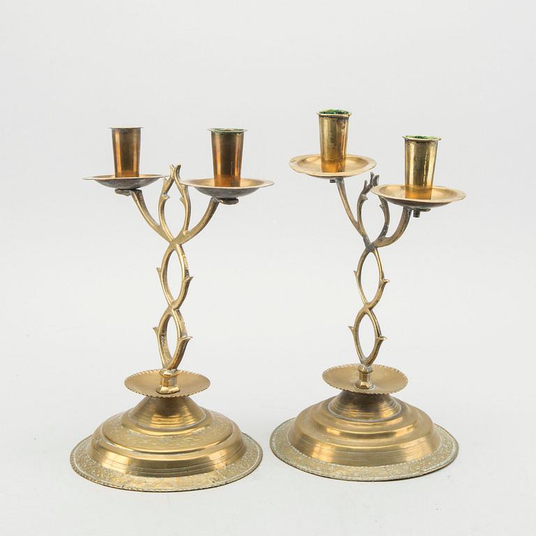 A pair of brass candelabras dated 1810 and 1812.