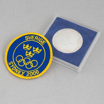 Deltagarmedalj OS, Sydney 2000 samt tygmärke för den svenska OS-truppen.