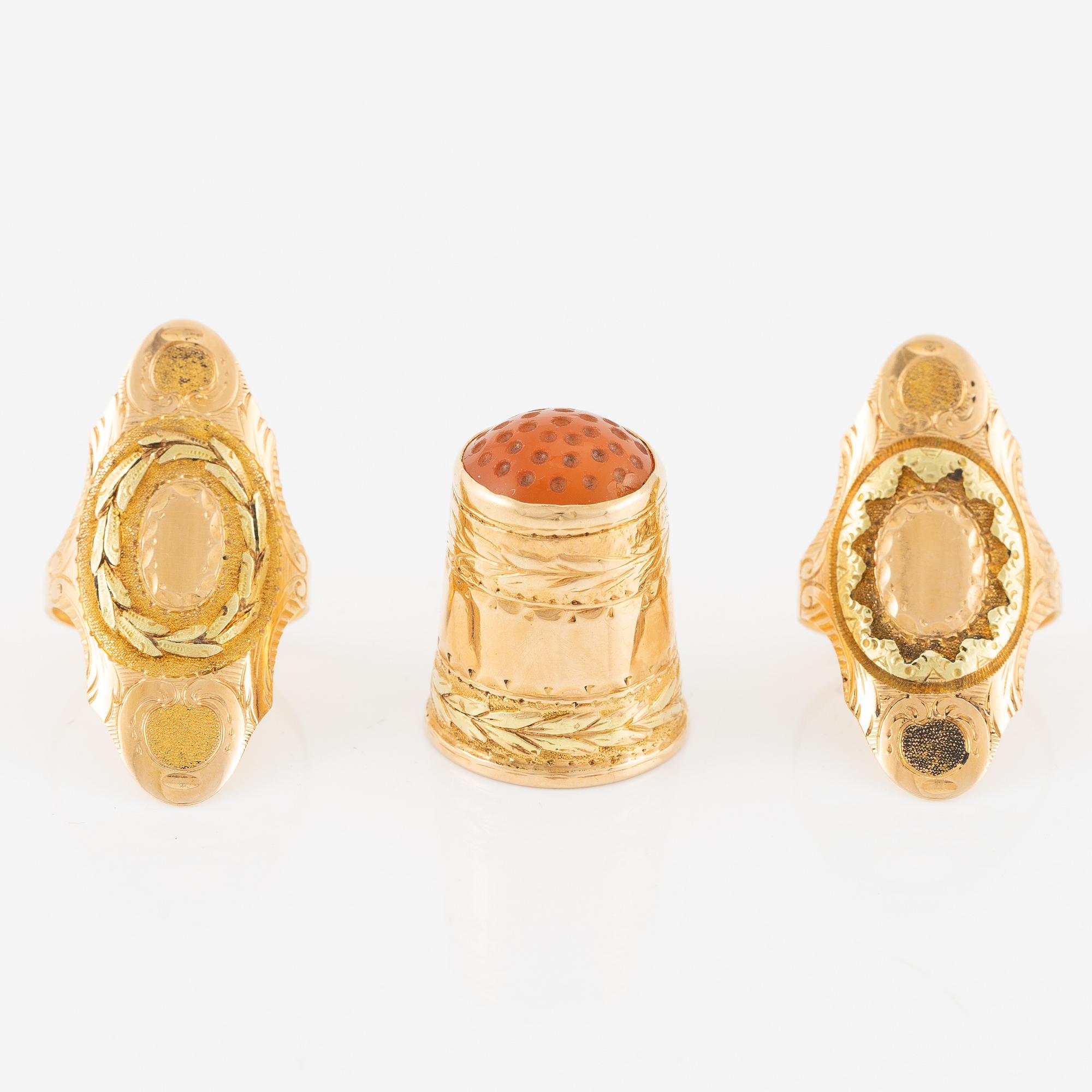 Thimble, finger guard and two rings, 18K gold, with fitted case.