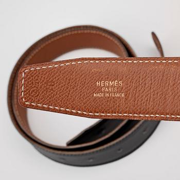 HERMÈS, four reversible belts, black and brown with gold coloured H belt buckle.