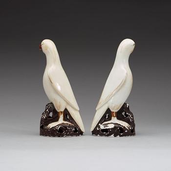 A pair of white andred glazed figures of parrots, late Qing dynasty.