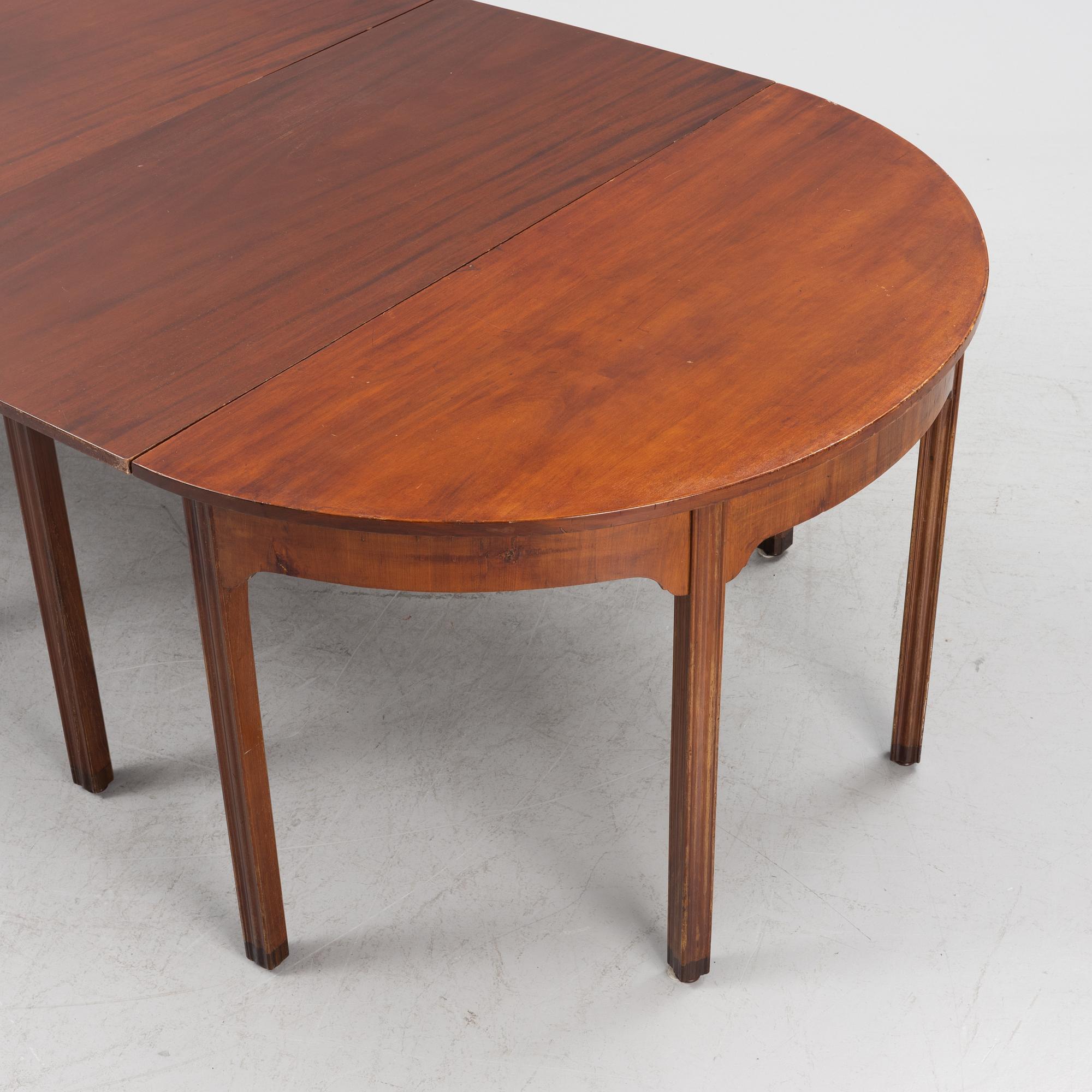 An English mahogany veneered George III style dining table, 19th Century.