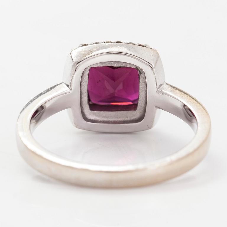 A 14K gold ring, with diamonds totalling approximately 0.095 ct and a garnet.