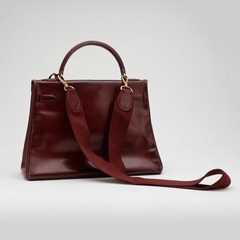 HERMÈS, a burgundy read leather "Kelly 32" bag, 1960's.