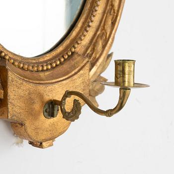 A Gustavian one-branch giltwood girandole mirror (with an associated copy), Stockholm, late 18th century.