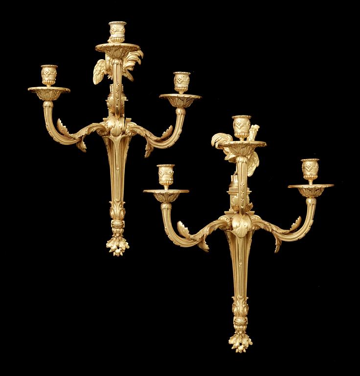 A pair of Louis XVI gilt bronze three-light wall-lights attributed to Jean-Louis Prieur, Paris circa 1770.