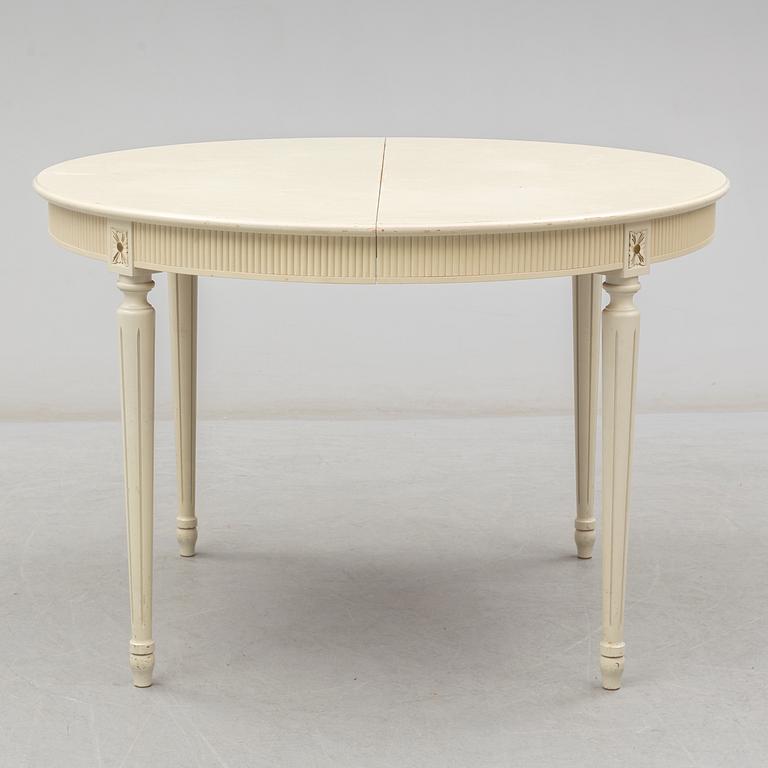 A set of eight chairs and a dining table. Gustavian style, second half of the 20th century. 2 leaves included.