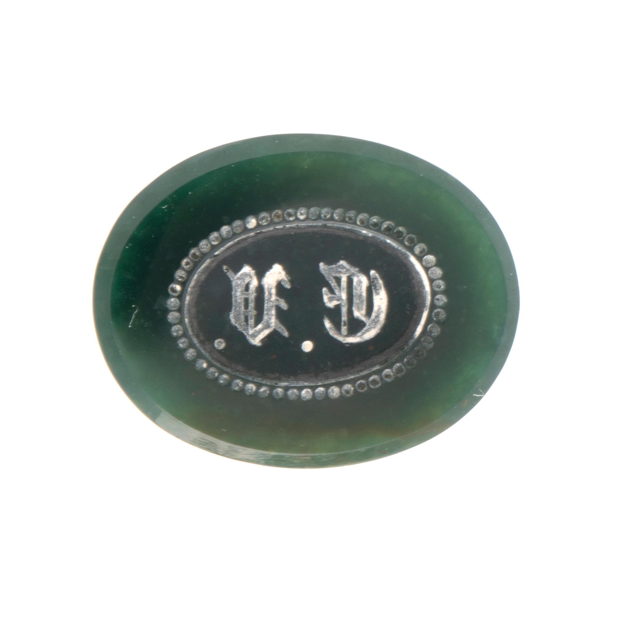 An 18K gold seal/pendant with green stone.