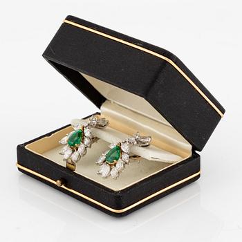 A pair of earrings in 18K white gold with drop-shaped faceted emeralds and diamonds.