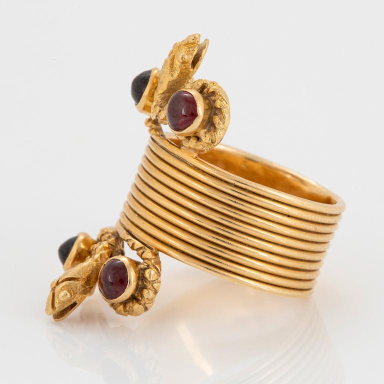 An 18K gold ring set with cabochon-cut garnets design Ilias Lalaounis.