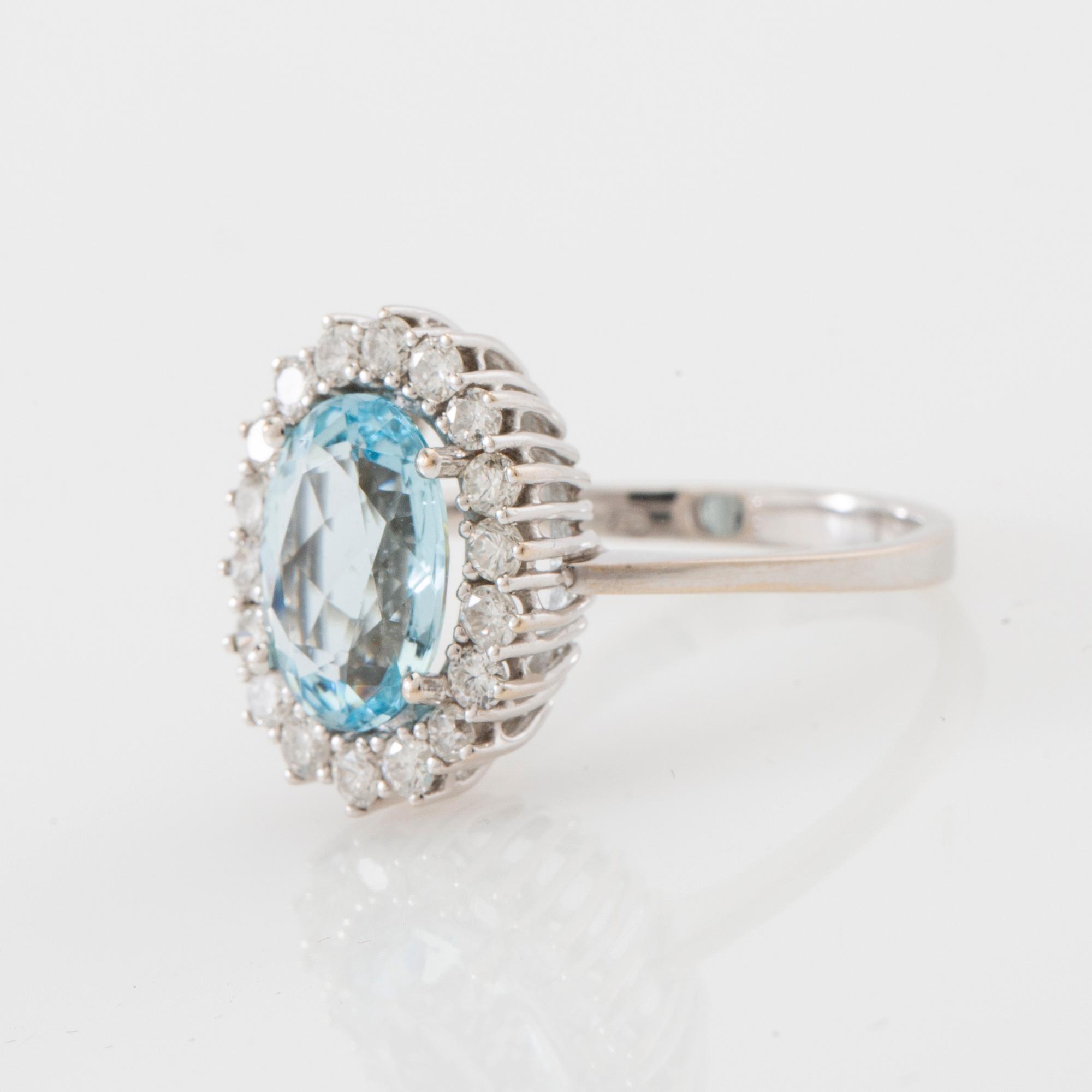 Ring 18K white gold set with an oval faceted aquamarine and round brilliant-cut diamonds.