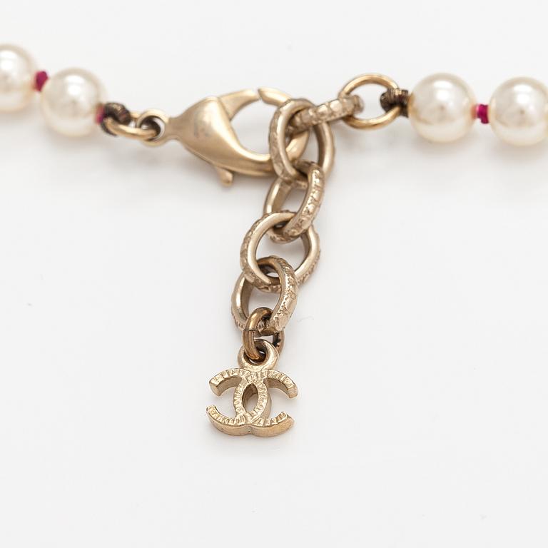 Chanel, A pearl collier with plastic pearls, glass stones and gold coloured metal parts. Marked Chanel, Made in France.