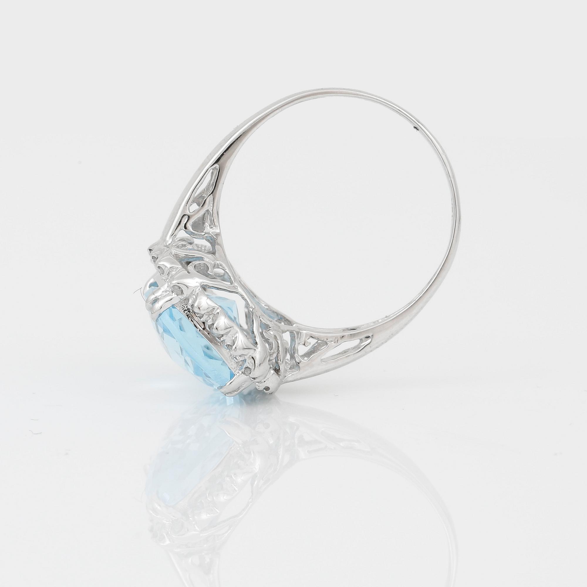 RING, 18K vitguld med chequerslipad blå topas, ca 5,23 ct, diamanter tot ca 0,20 ct. Vikt ca 4,17 g.