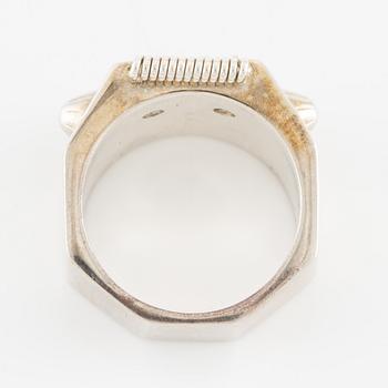Maria Nilsdotter ring i form av ett robothuvud, sterlingsilver och gröna ögon.