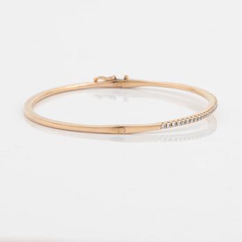 An 18K rose gold bangle set with round brilliant-cut diamonds.