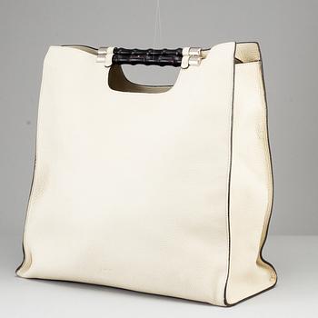 GUCCI, a white leather tote bag with bamboo handles.