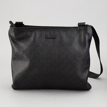 Gucci, a leather messenger bag.