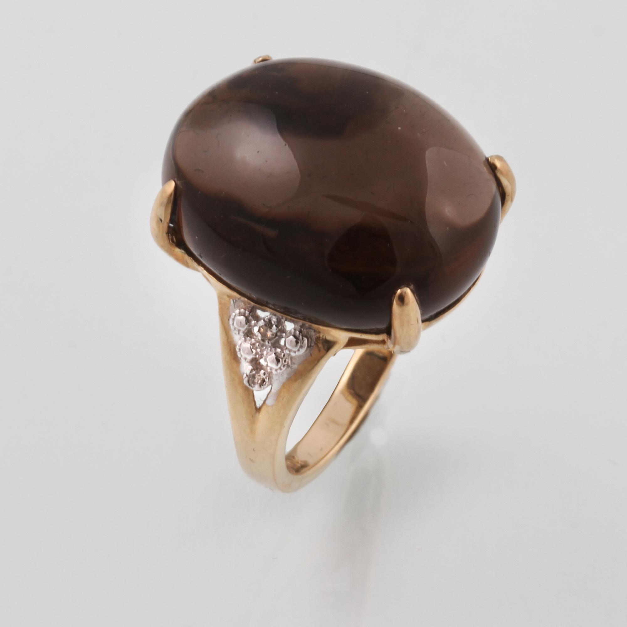 RING, 10K guld med cabochonslipad rökkvarts samt 4 åttkantsliapde diamanter. Vikt 7,2 gram.