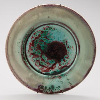 A mid-20th century glazed ceramic dish, signed TM.