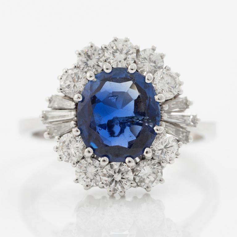 Ring in 18K white gold set with a faceted sapphire and round brilliant-cut and modified baguette-cut diamonds.