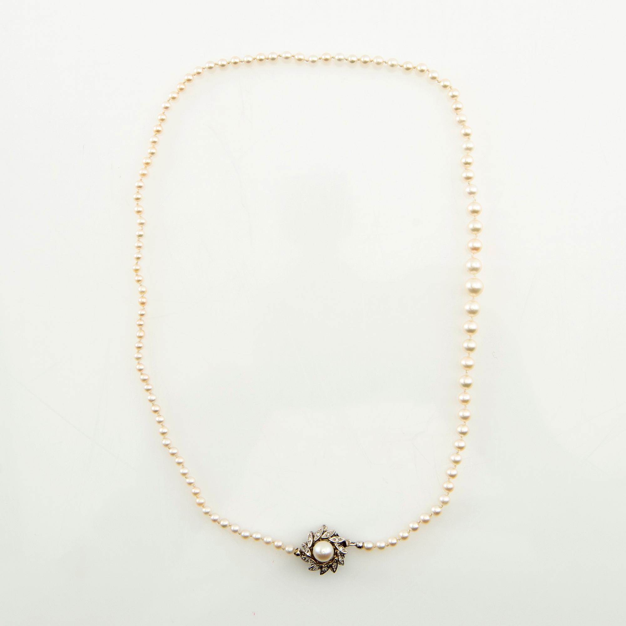 Necklace of cultured pearls and a clasp of 18K white gold set with round brilliant-cut diamonds and a cultured pearl.