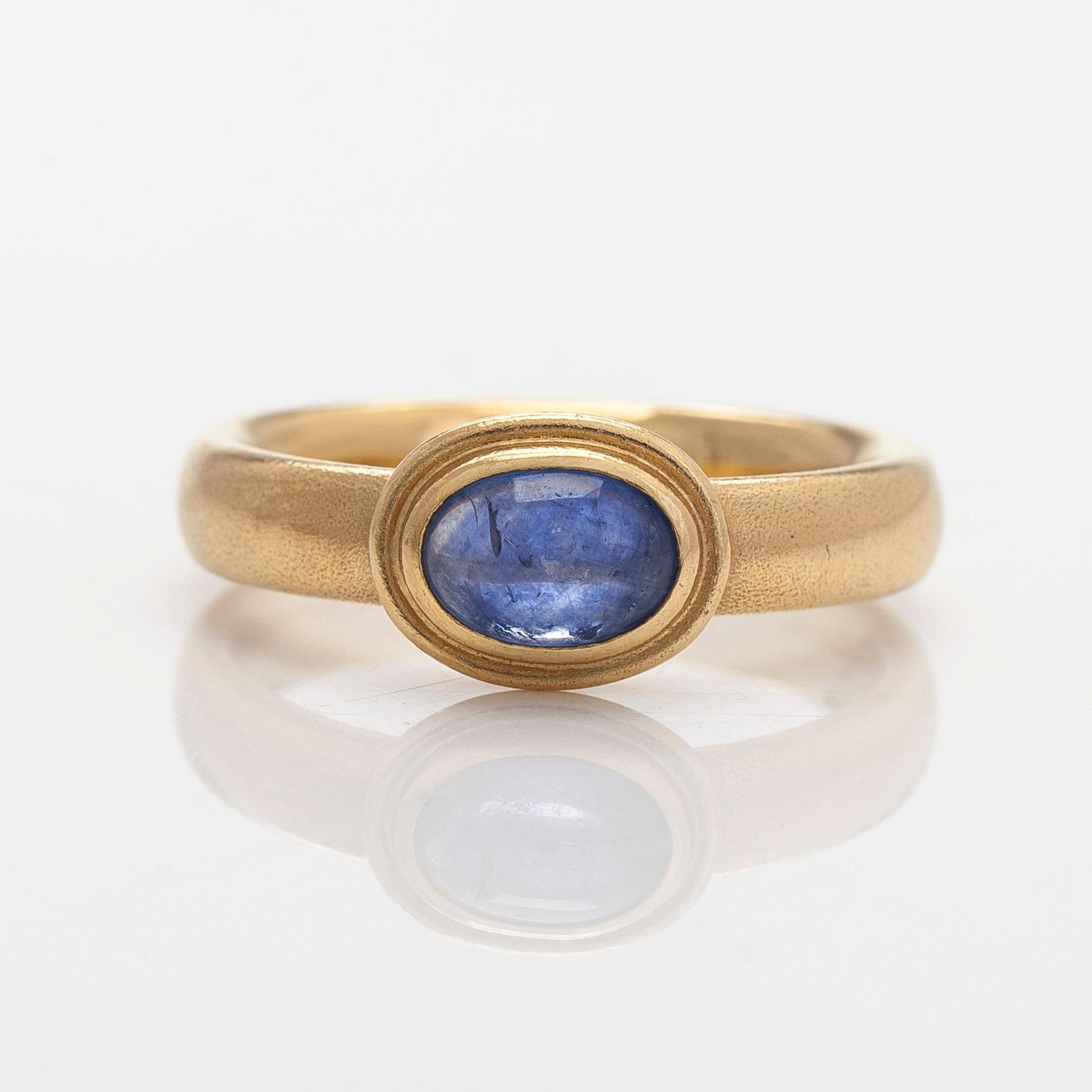 An 18K gold ring with a cabochon-cut sapphire.