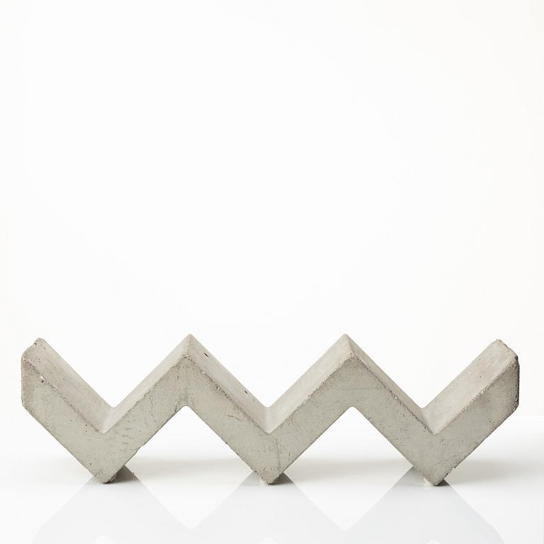 A mixed lot comprising a pair of limestone bookends, a bookshelf and two plates in concrete.