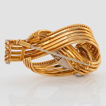 A Gübelin brooch in 18K gold set with round brilliant-cut diamonds.