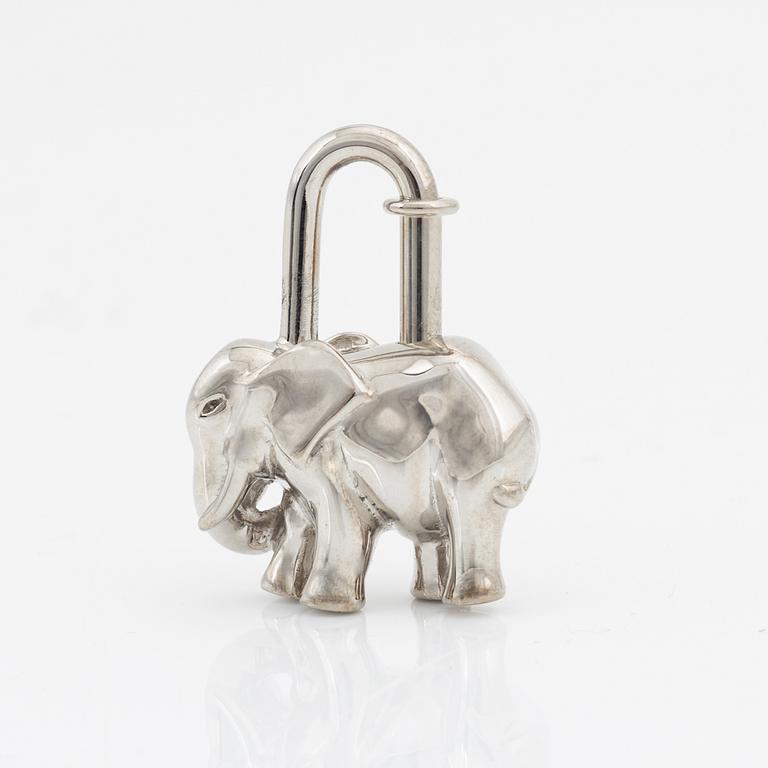 Hermès, a silver cadena lock bag charm.