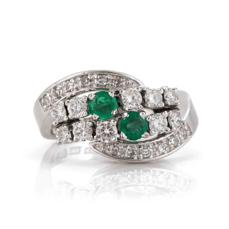 A ring set with round, mixed-cut emeralds and eight-cut and round, brilliant-cut diamonds.