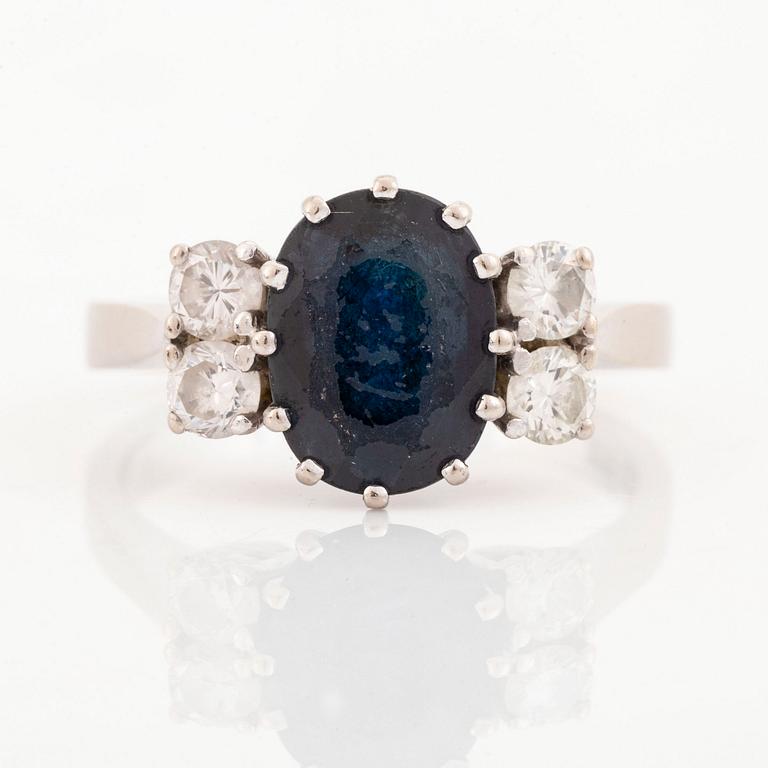 Ring with dark blue oval sapphire and brilliant-cut diamonds.