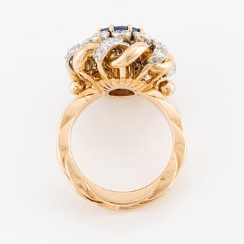 An 18K gold  ring with a sapphire and round brilliant-cut diamonds.