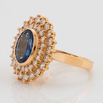 An 18K gold ring set with a faceted sapphire ca 3.50 cts and round brilliant-cut diamonds.