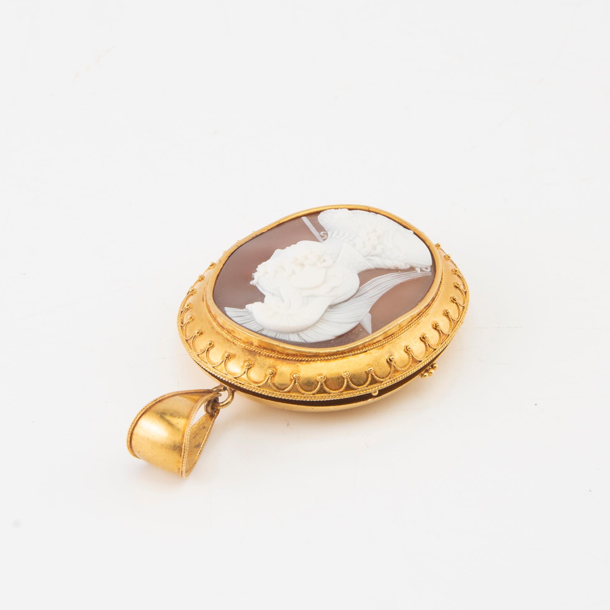 A 14K gold medallion with carved shell cameo.