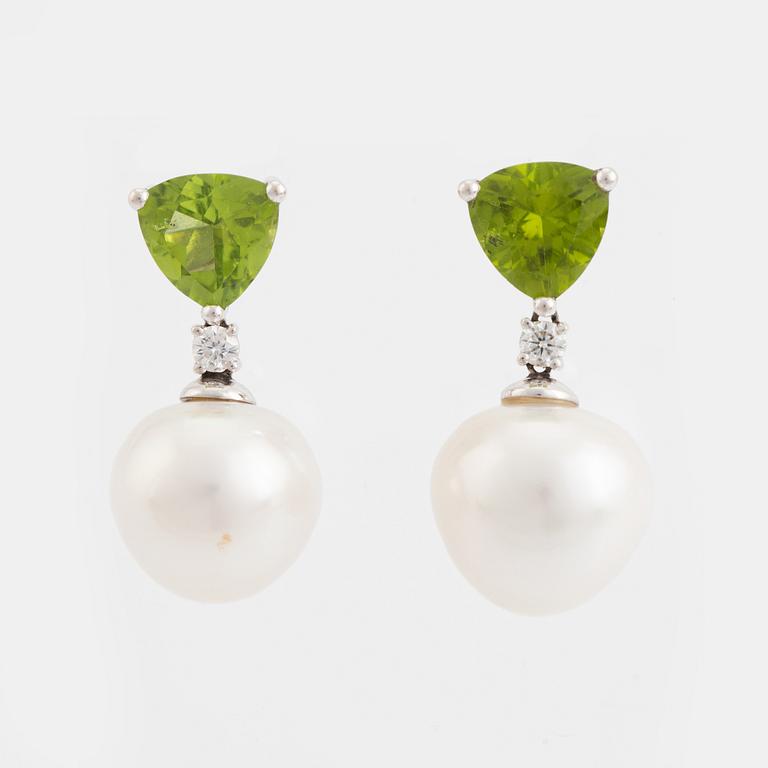 Ett par örhängen med South sea pärlor, peridoter och briljantslipade diamanter.