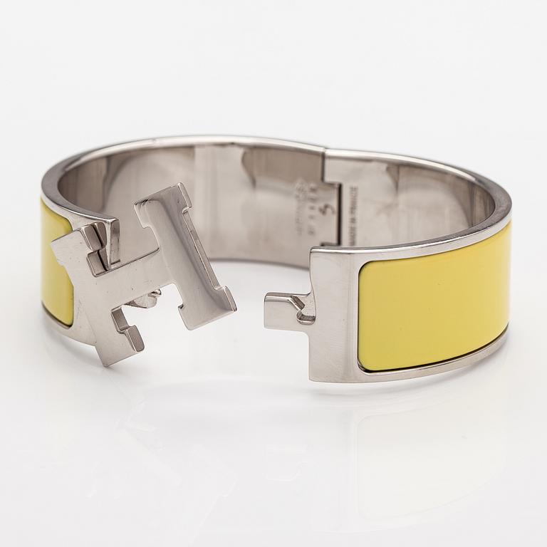 Hermès, A "Click H" bracelet made of metal and yellow enamel. Marked Hermès, ST1105, S, Made in France.