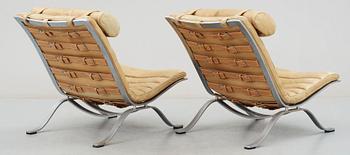 A pair of Arne Norell "Ari" brown leather and steel easy chairs by Norell.
