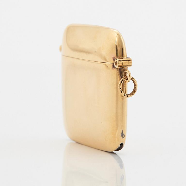 An 18K gold match case/pendant set with a faceted sapphire.