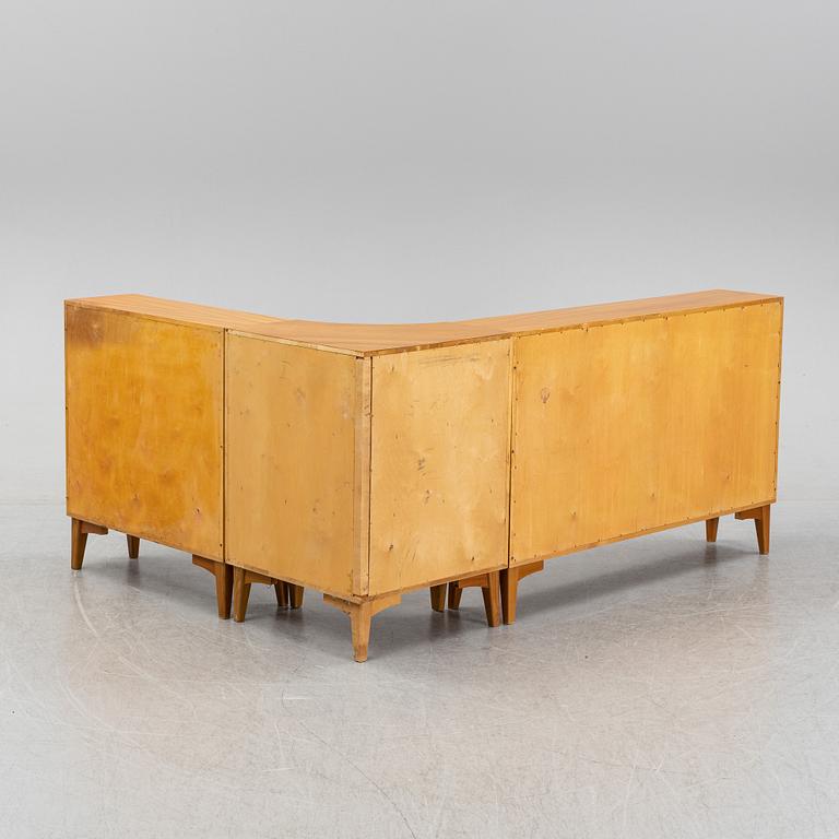 A three piece corner book case with a cabinet.
