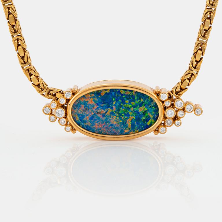 An 18K gold pendant set with an opal and round brilliant-cut diamonds.