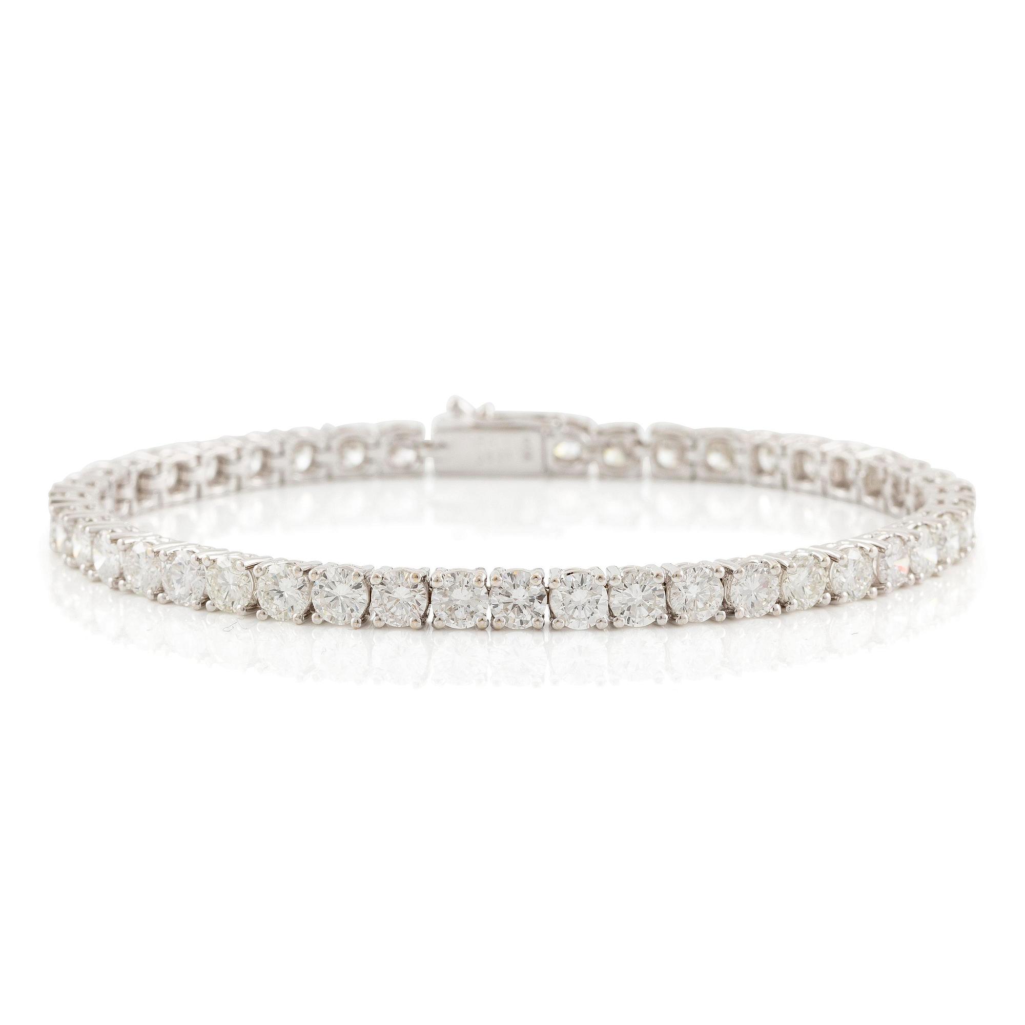 An 18K white gold tennis bracelet set with round brilliant-cut diamonds.