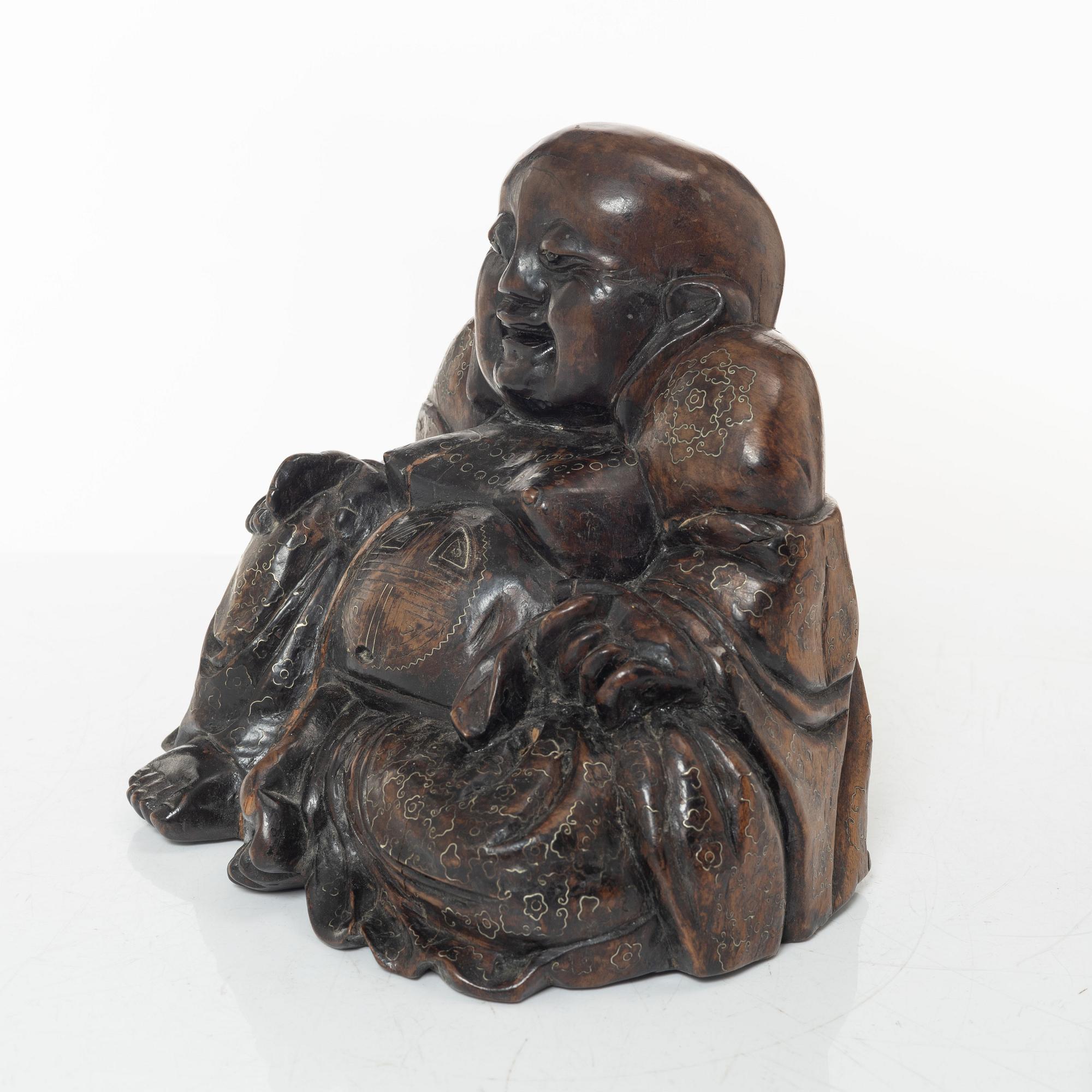 A Chinese wooden figure of Budai with silver inlays, Qing dynasty (1644-1912).