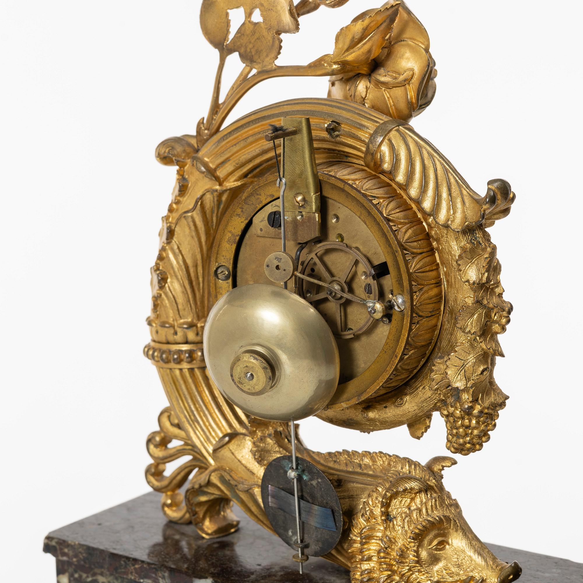 A presumably French Empire-style gilt bronze and marble mantel clock, later part 19th century.