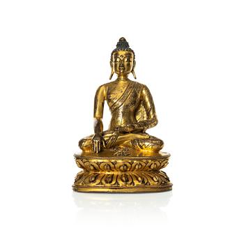 909. A gilt copper-alloy figure of Aksobhya Buddha, 14th/15th century, Tibet or Nepal.