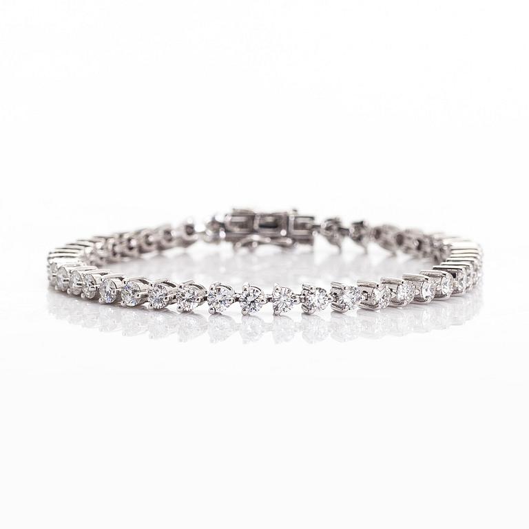 An 18K white gold tennis bracelet, with brilliant-cut diamonds.