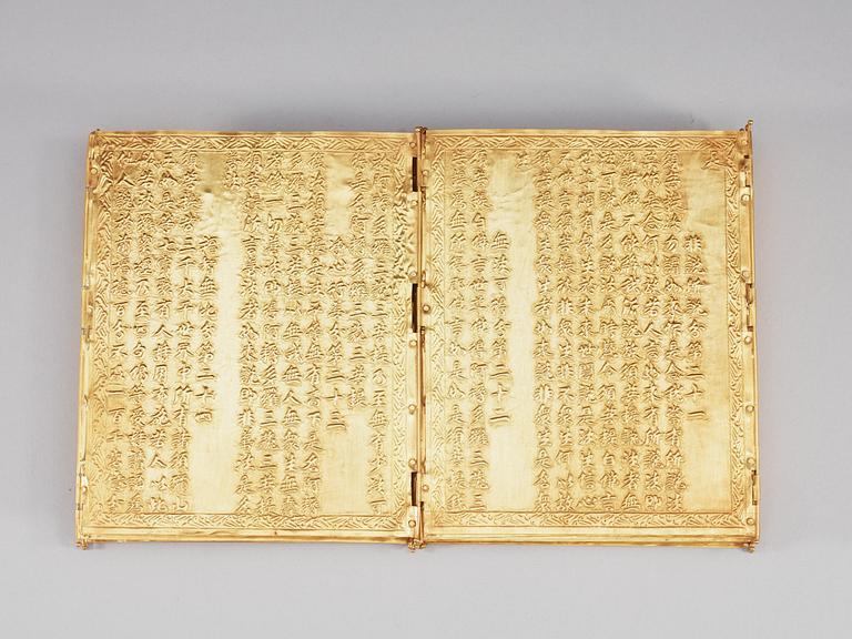 A repousse technique gilt metal box with a book of buddhistic prayers, China.