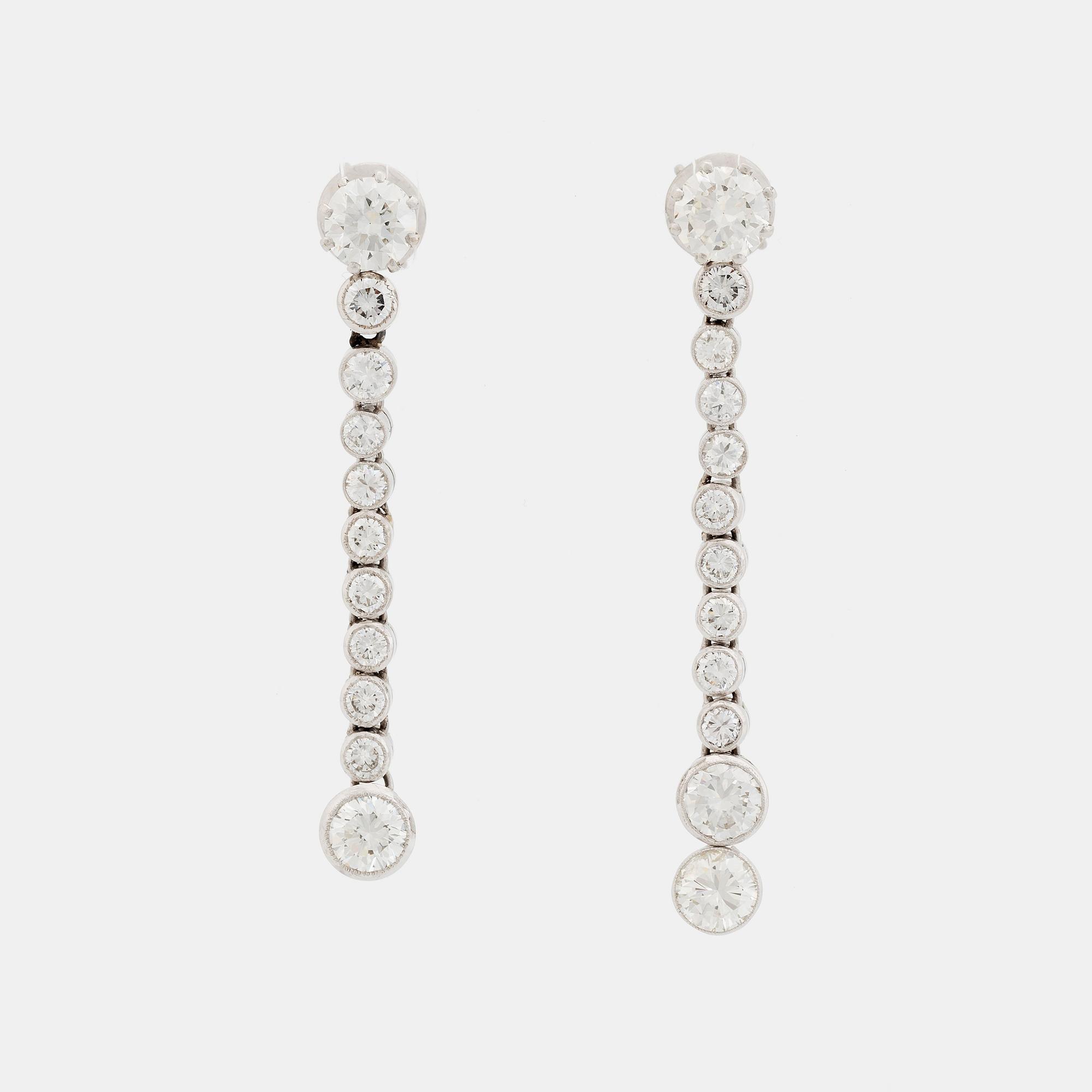 A pair of 18K white gold earrings set with round brilliant-cut diamonds.