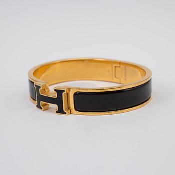 Black enamel and golden bracelet "Clic H" by Hermès.